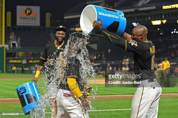 Andrew McCutchen of the Pittsburgh Pirates gets a bucket of water dumped on him by Starling Marte after the final out in the Pittsburgh Pirates 10-1...
