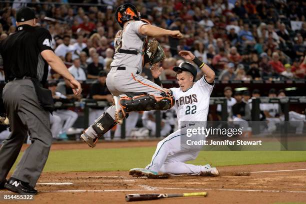 Jake Lamb of the Arizona Diamondbacks safely slides to score against Nick Hundley of the San Francisco Giants in the second inning at Chase Field on...