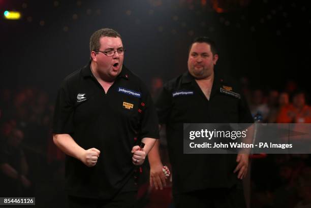 Stephen Bunting celebrates winning a crucial leg as Alan Norris looks on dejected during the BDO World Championships Final at the Lakeside Complex,...