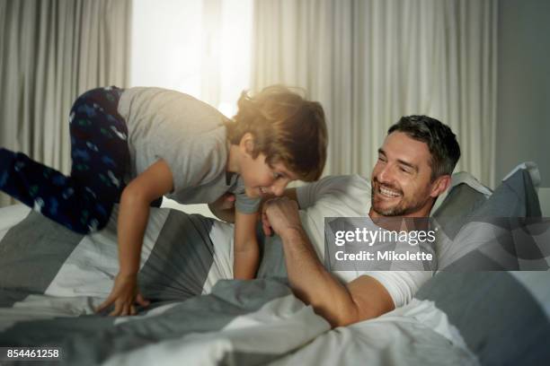 wake up dad! it’s time to play! - children jumping bed stock pictures, royalty-free photos & images