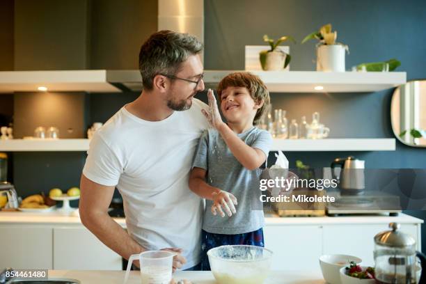 dad, the flour's supposed to go in the batter - cooking mess imagens e fotografias de stock