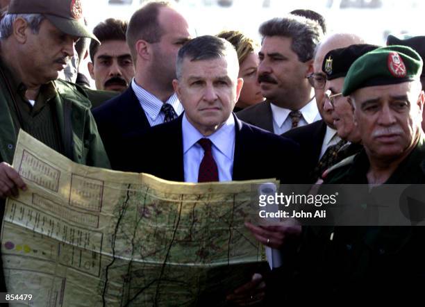 Palestinian police officials show a map of the Jewish settlement to the U.S. Mediator for the Middle East Anthony Zinni December 1, 2001 during his...