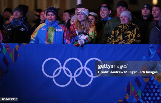 Volunteers gather to watch the opening ceremony for the 2014 Sochi Olympic Games on giant tv screens in Rosa Khutor, Russia.