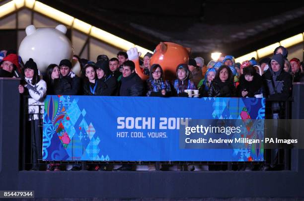 Volunteers gather to watch the opening ceremony for the 2014 Sochi Olympic Games on giant tv screens in Rosa Khutor, Russia.