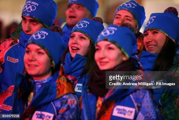 Volunteers gather to watch the opening ceremony for the 2014 Sochi Olympic Games on giant tv screens in Rosa Khutor, Russia.