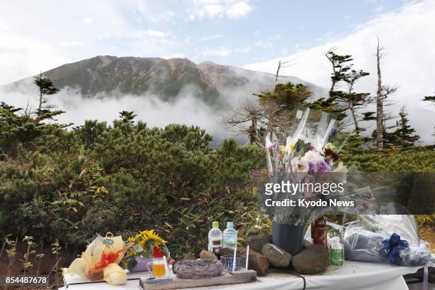 Flowers are offered near the seventh station of Mt. Ontake in central Japan on Sept. 27 the third anniversary of the eruption that claimed 58 lives...