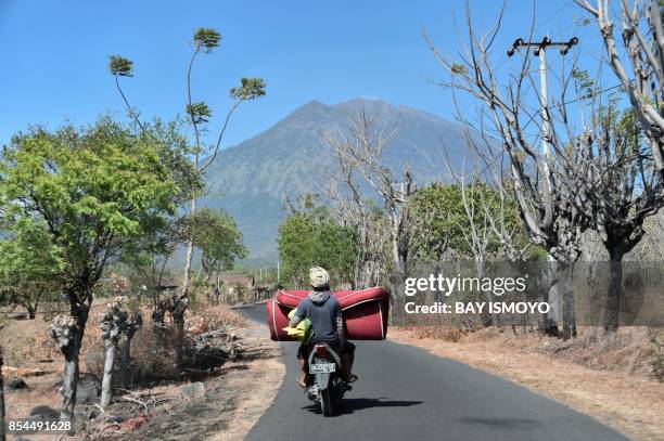 Villagers transport a mattress back to their home in Kubu village near the base of Mount Agung volcano , in Karangasem Regency on the Indonesian...