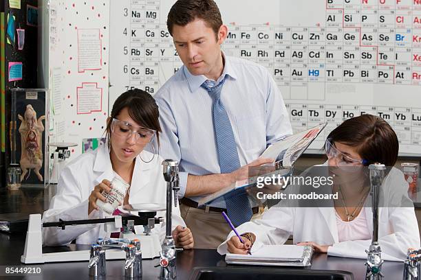 science teacher helping student - periodic table of elements stock pictures, royalty-free photos & images