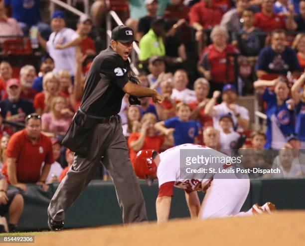 Third base umpire Jim Reynolds calls out the St. Louis Cardinals' Jedd Gyorko, who was trying to take two bases on a single by Paul DeJong in the...