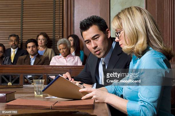 lawyer defending client with jury in court - legal defense stock pictures, royalty-free photos & images