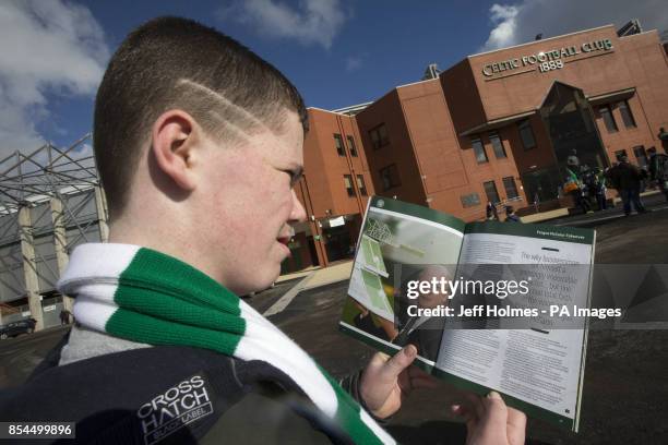 Young Celtic Fan Conor Bailey reads about Celtic savour Fergus McCann in the matchday programme as the club celebrates 20 years to the day since he...