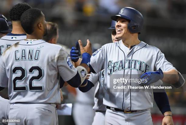 Danny Valencia and Robinson Cano of the Seattle Mariners celebrates after Valencia hit a three-run homer against the Oakland Athletics in the top of...