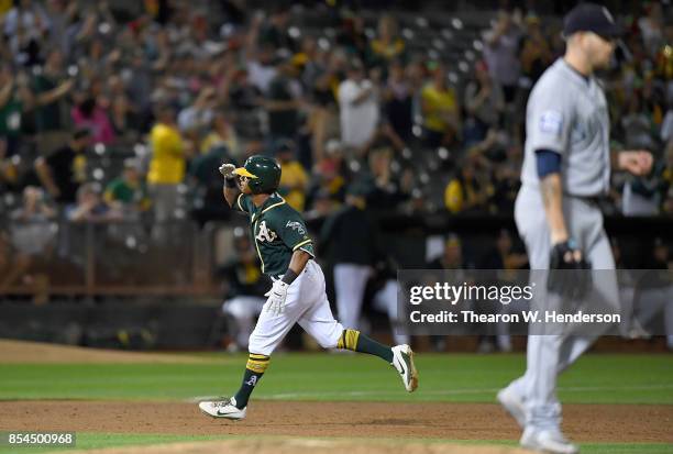 Khris Davis of the Oakland Athletics salutes as he trots around the bases after hitting a two-run homer off of James Paxton of the Seattle Mariners...