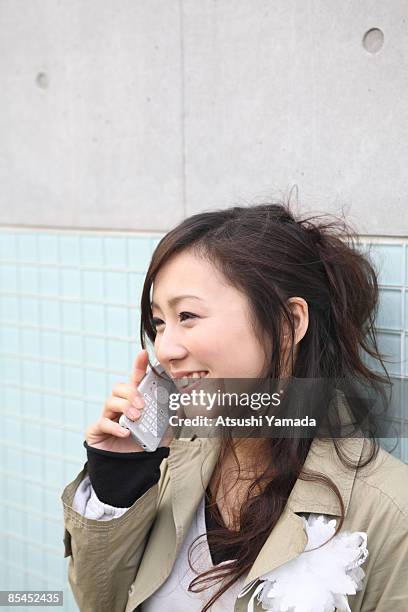young woman using mobile phone, smiling - atsushi yamada stock pictures, royalty-free photos & images