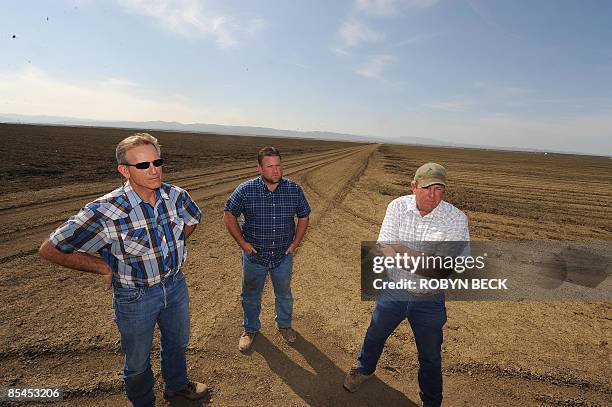 Todd Diedrich is flanked by his uncles Bill and Bob on some 600 acres of his farmland which will not be planted this season due to lack of water, in...