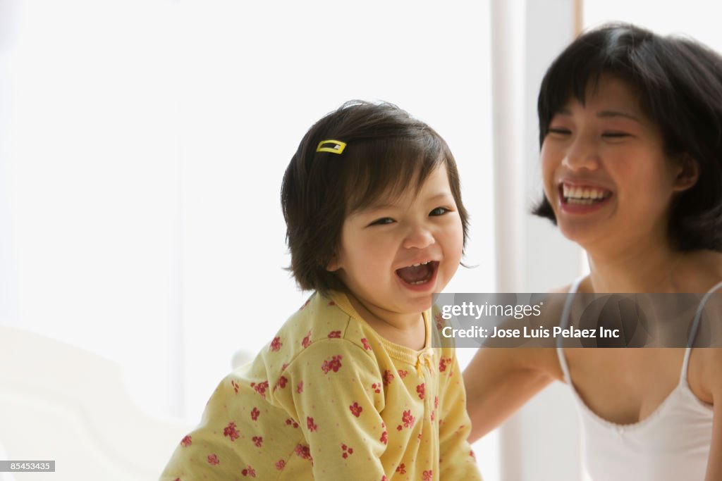 Mixed race girl laughing with mother