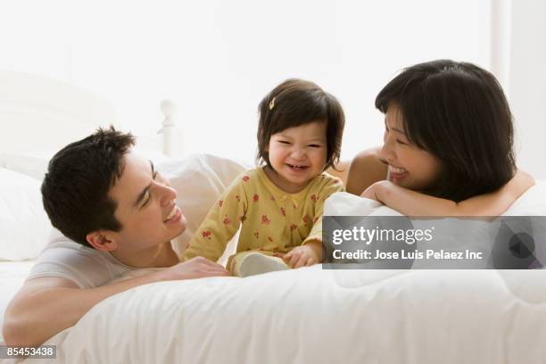 mixed race girl laughing with parents - mom flirting stockfoto's en -beelden