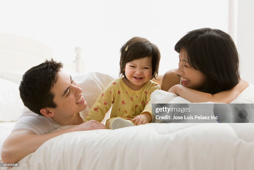 Mixed race girl laughing with parents