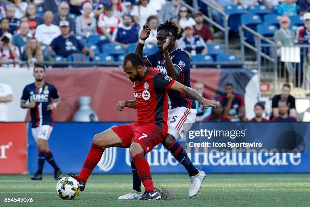 Toronto FC midfielder Victor Vazquez shields off New England Revolution midfielder Gershon Koffie during a match between the New England Revolution...