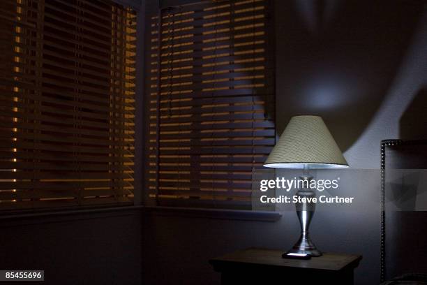 lamp on bedroom nightstand. - window with blinds inside stock pictures, royalty-free photos & images