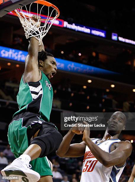 Chris Bosh of the Toronto Raptors reacts after a dunk against Emeka Okafor of the Charlotte Bobcats during their game at Time Warner Cable Arena on...