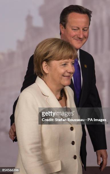 Prime Minister David Cameron and German Chancellor Angela Merkel leave the stage after posing for a family photograph during the G7 Summit held at...