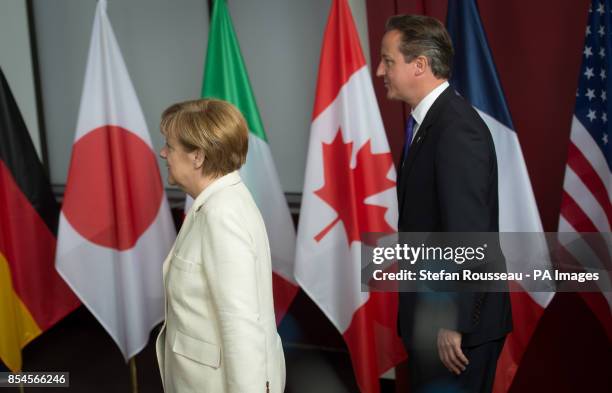 Prime Minister David Cameron and German Chancellor Angela Merkel arrive on stage for a family photograph during the G7 Summit held at the EU...