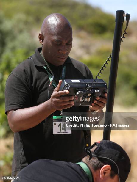 Member of the search team looks at a screen while a camera is placed inside an drain next to an area of wasteland during the search for evidence of...