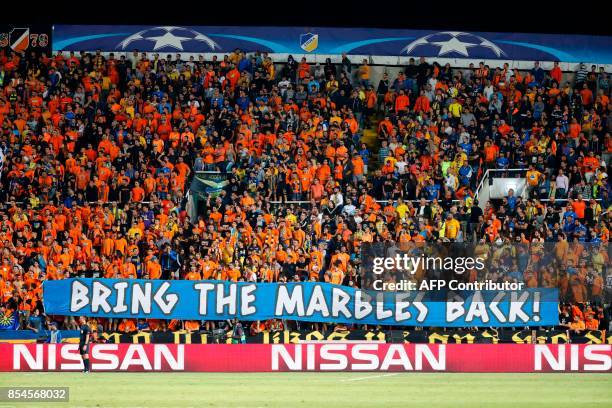 Apoel FC's fans hold a banner reading in English "bring the marbles back" during the UEFA Champions League football match between Apoel FC and...