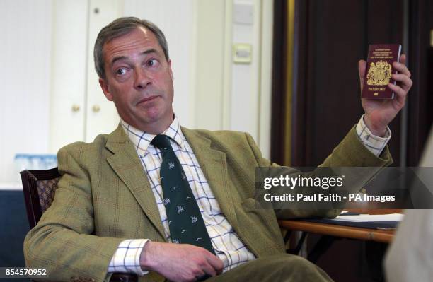 Leader Nigel Farage holds up his passport as he is being interviewed by the Press Association in Belfast during a one day visit to the province where...