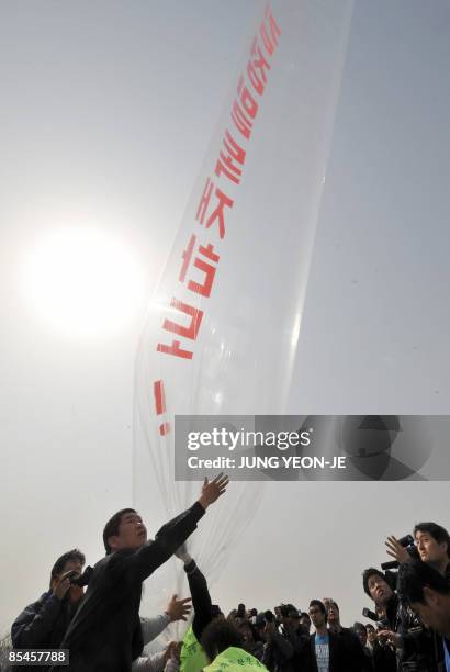 South Korean activists float a balloon carrying anti-Pyongyang leaflets and North Korean banknotes across the border into North Korea at the Imjingak...