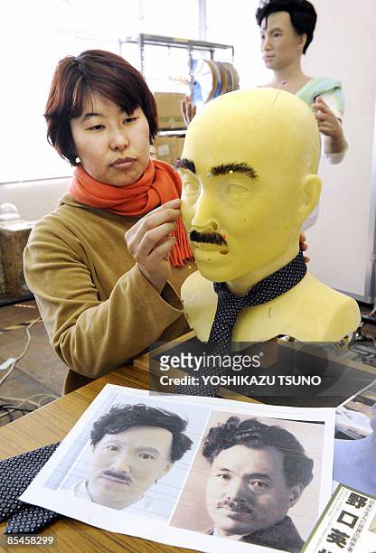 Designer from Japan's robot maker Kokoro puts a eyebrows and a facial hair on a humanoid robot resembling prominent Japanese doctor and...