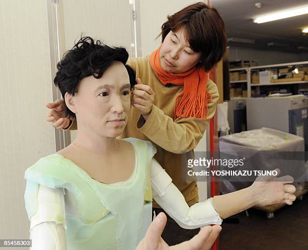 Designer from Japan's robot maker Kokoro puts a hairpiece on a humanoid robot resembling prominent Japanese doctor and bacteriologist Hideyo Noguchi,...