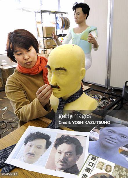 Designer from Japan's robot maker Kokoro puts a eyebrows and a facial hair on a humanoid robot resembling prominent Japanese doctor and...