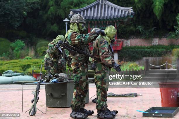 South Korean soldiers wearing chemical protective gears participate in a decontamination training at a stadium in Seoul on September 27, 2017. The...