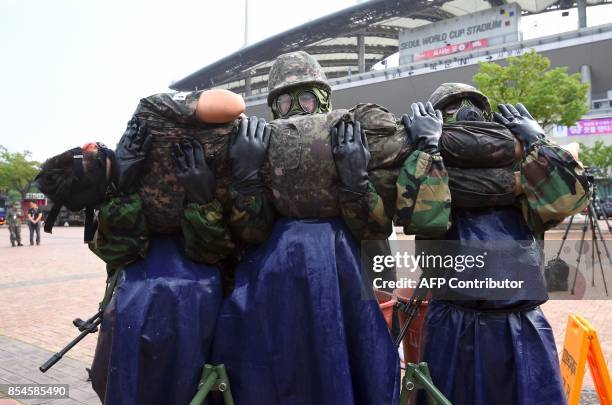 South Korean soldiers wearing chemical protective gears participate in a decontamination training at a stadium in Seoul on September 27, 2017. The...