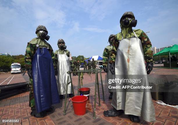 South Korean soldiers wearing chemical protective gears participate in a decontamination training at a stadium in Seoul on September 27, 2017. The...
