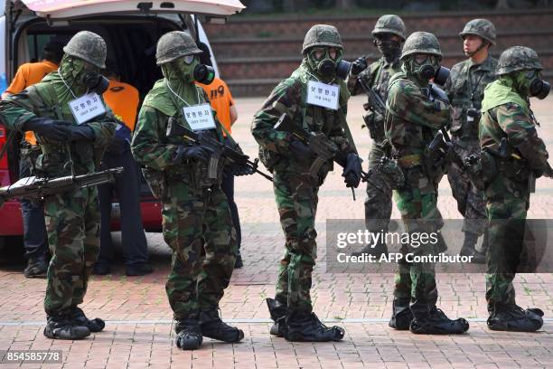 South Korean soldiers wearing chemical protective gears participate in a decontamination training at a stadium in Seoul on September 27, 2017. The...