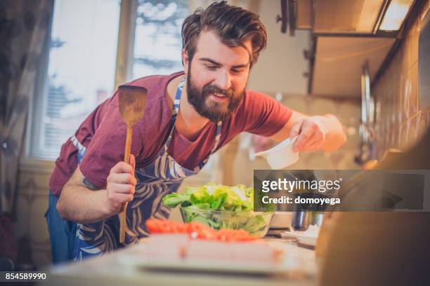 handsome bearded man making healthy meal in the kitchen - molho vinagrete imagens e fotografias de stock