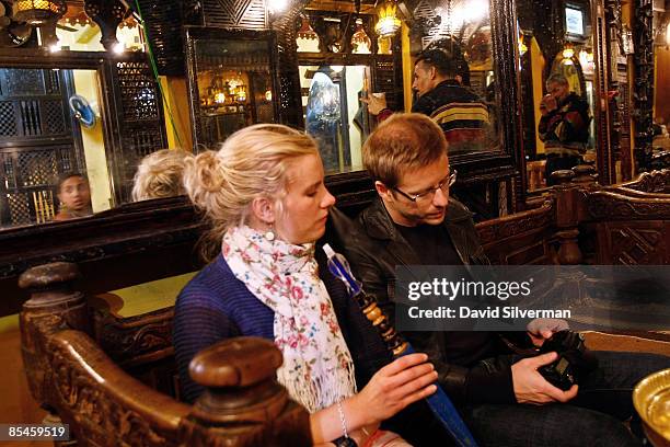 Tourist couple relax with a sheesha, also known as a water-pipe or nargilla, at the el-Fishawi coffee shop, made famous by the Egyptian Nobel prize...