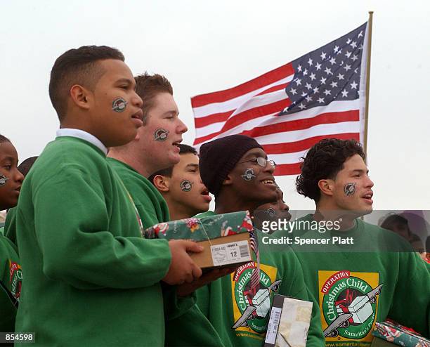Operation Christmas Child volunteers participate in a ceremony, before an airlift of 90,000 gifts to needy children in Afghanistan, December 12, 2001...