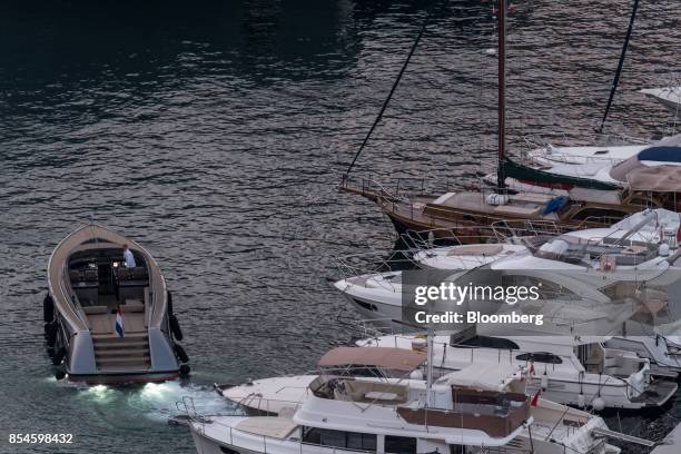 The national flag of the Netherlands flies from the stern of a tender speed boat as it sails in the harbor ahead of the Monaco Yacht Show in Port...