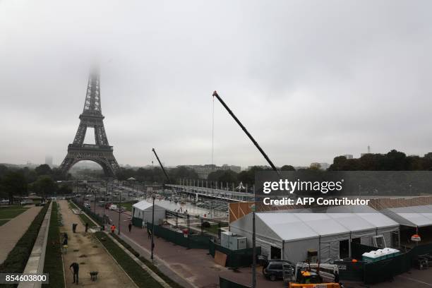 View of the Eiffel Tower used as a back drop for the runway of a major fashion house during Paris Fashion Week on September 27, 2017. / AFP PHOTO /...