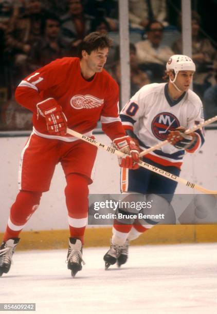 Pete Mahovlich of the Detroit Red Wings skates on the ice as he is defended by Lorne Henning of the New York Islanders during an NHL game on November...