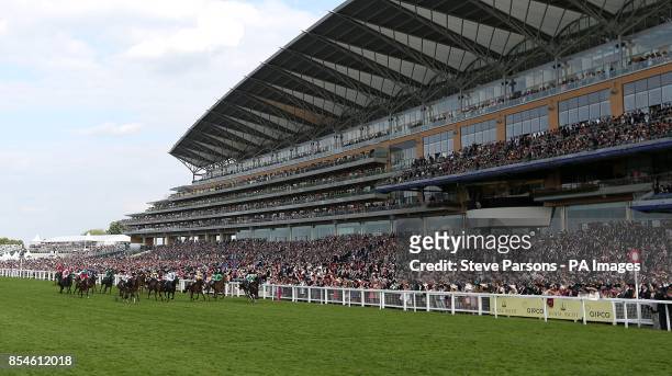 Runners and riders pass the grandstand in the Buckingham Palace Stakes during Day Four of the 2014 Royal Ascot Meeting at Ascot Racecourse, Berkshire.