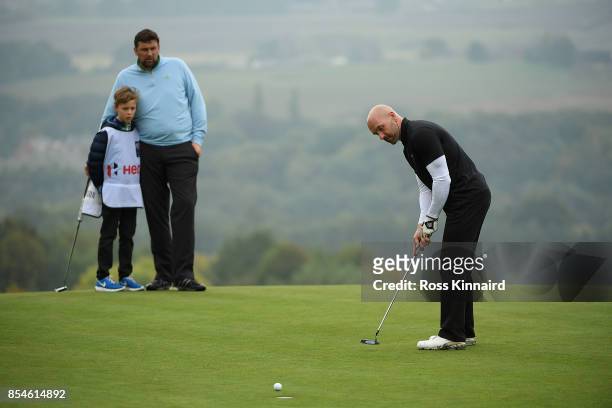Former footballer Steve Stone putts as former cricketer Steve Harmison watches during the pro am ahead of the British Masters at Close House Golf...