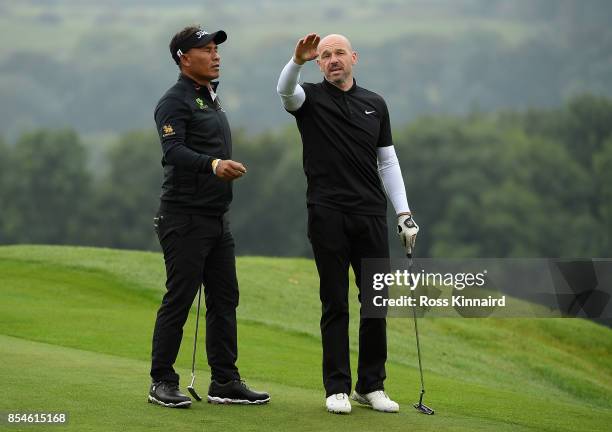 Thongchai Jaidee of Thailand speaks with former footballer Steve Stone during the pro am ahead of the British Masters at Close House Golf Club on...