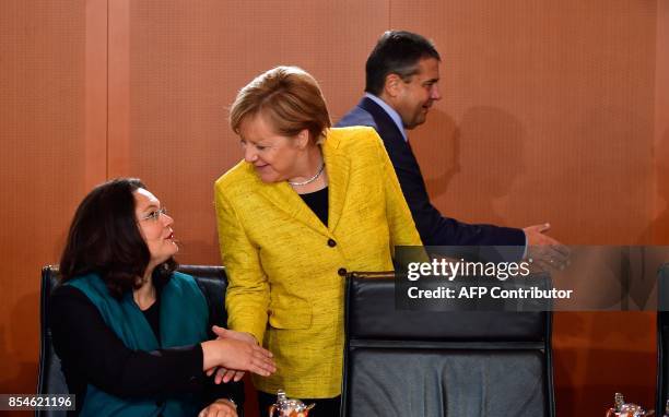 German Chancellor Angela Merkel shakes hands with German Labour and Social Minister Andrea Nahles as German Vice Chancellor and Foreign Minister...