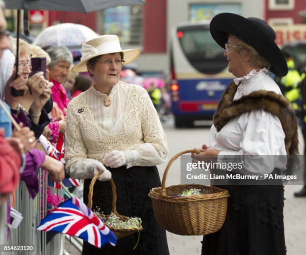Two ladies dressed in 1914 period costume to mark the year of the Great War, before Queen Elizabeth II and The Duke of Edinburgh arrive at Coleraine...