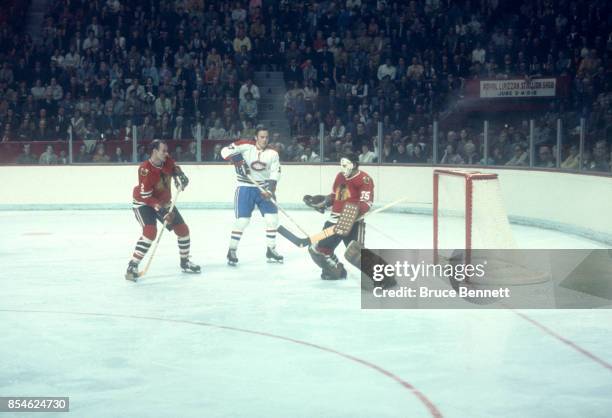 Frank Mahovlich of the Montreal Canadiens looks for the rebound as goalie Tony Esposito and Bill White of the Chicago Blackhawks defend the net...